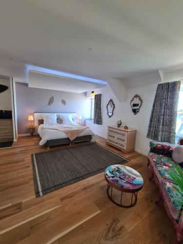 a large bedroom with a bed and a couch at Les Suites du Dossen in Santec