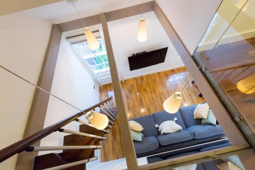 a living room with a blue couch and a staircase at Spacious 4 bedrooms flat in New Oxford Street in London