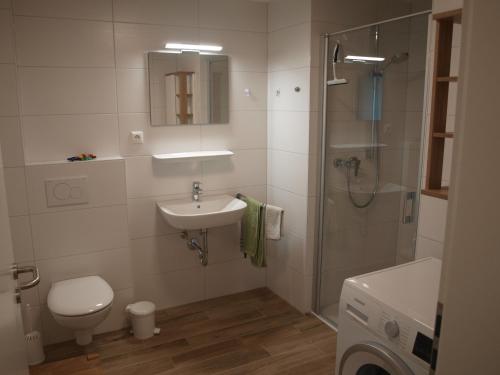 uma casa de banho com um WC, um lavatório e um chuveiro em Haus Dornröschen em Schweiburg