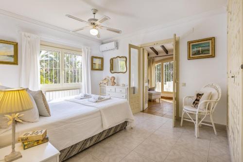a bedroom with a bed and a table and chairs at Villa Levante in Jávea