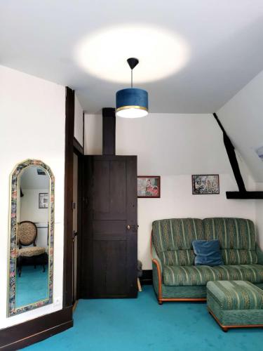 a living room with a couch and a mirror at Château De Swann in Illiers