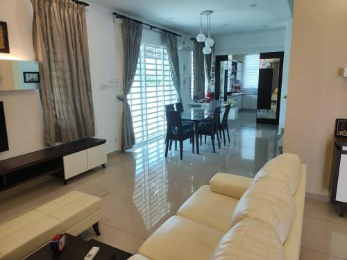 a living room with a couch and a dining room at Prestij 3 Homestay, Balik Pulau in Balik Pulau