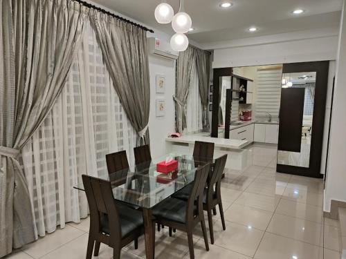 a dining room with a glass table and chairs at Prestij 3 Homestay, Balik Pulau in Balik Pulau
