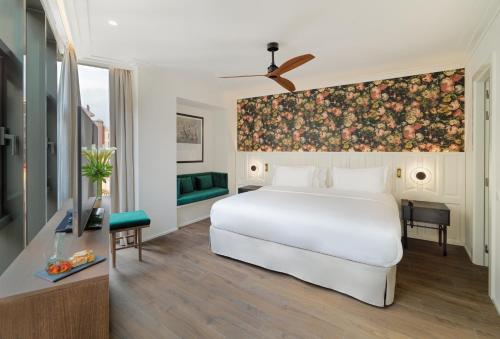 a bedroom with a white bed and a floral wall at H10 Casanova in Barcelona