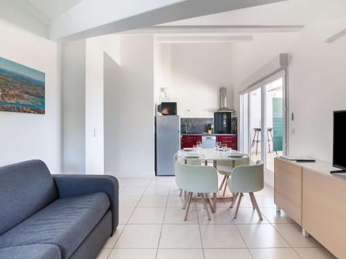 un salon avec un canapé et une table avec des chaises dans l'établissement Appartement moderne à Hendaye, 400m de la plage, terrasse, parking et WiFi inclus - FR-1-2-371, à Hendaye