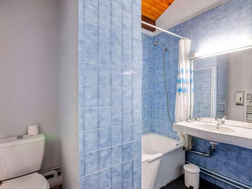 a blue tiled bathroom with a toilet and a sink at Appartement Hendaye, 2 pièces, 5 personnes - FR-1-2-390 in Hendaye