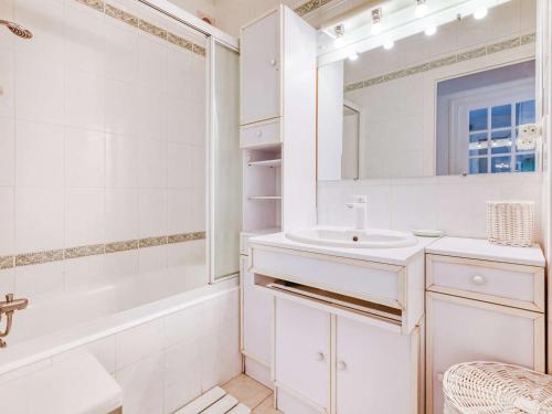 ein weißes Badezimmer mit einem Waschbecken und einem Spiegel in der Unterkunft Appartement Hendaye, 3 pièces, 4 personnes - FR-1-2-394 in Hendaye