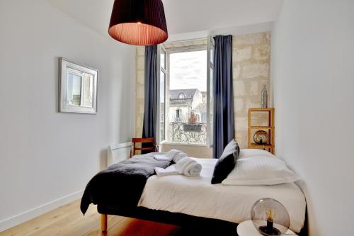 - une chambre avec un lit en face d'une fenêtre dans l'établissement L'Entre Deux - Magnifique T3 quartier Saint Michel, à Bordeaux