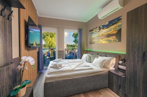sypialnia z dużym łóżkiem i oknem w obiekcie Mártoni Resort & Restaurant w mieście Szigetszentmárton