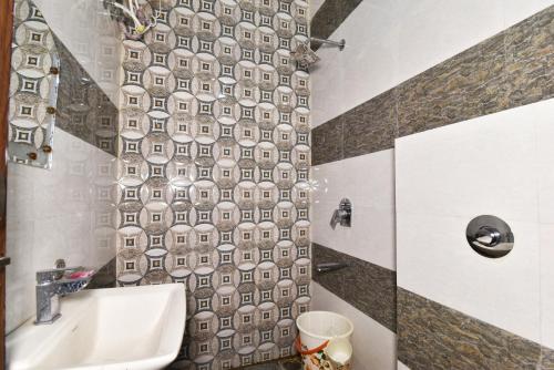 a bathroom with a shower with a tile wall at Hotel Sai Sham in Amritsar