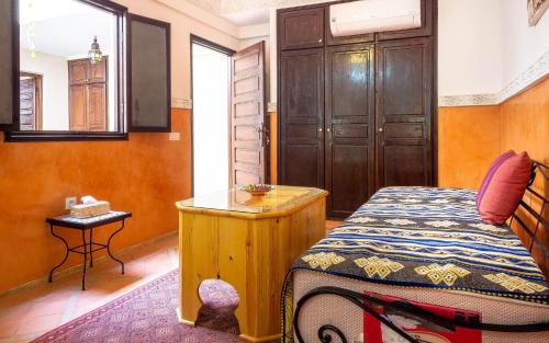 a bedroom with a bed and a table in it at RIAD BIEN ICI in Marrakesh