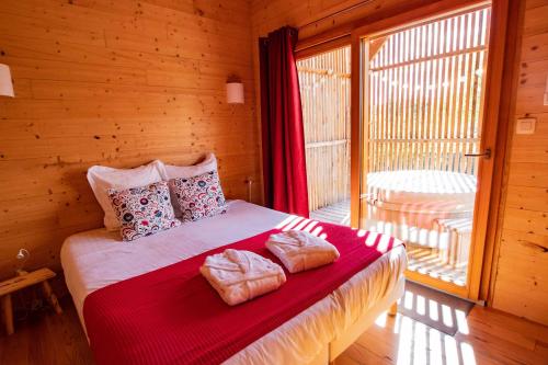 een slaapkamer met een bed met twee handdoeken erop bij Les Lodges de la ViaRhôna / cabane-spa in Virignin