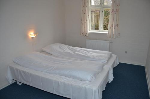 a white bed sitting in a room next to a window at Motel Lido in Bredebro