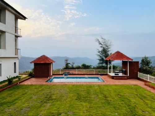 a backyard with a swimming pool and a house at Konark Villa in Mahabaleshwar