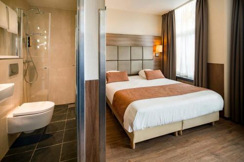 a hotel room with a bed and a shower at OZO Hotels Cordial Amsterdam in Amsterdam