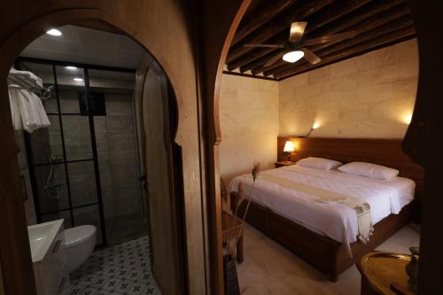 a bedroom with a bed and a bathroom with a shower at CEVHER KONAĞI in Halfeti