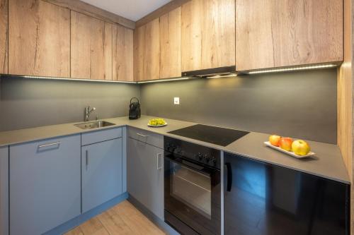 una cocina con armarios de madera y una bandeja de fruta en Anita, en Zermatt
