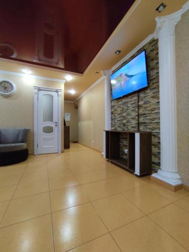 een woonkamer met een flatscreen-tv aan de muur bij Comfortable Apartment in Krementsjoek