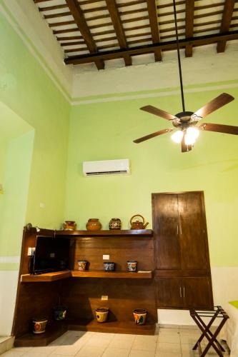 a living room with a ceiling fan and a television at Hotel Boutique La Mision De Fray Diego in Mérida