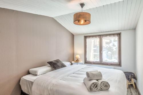 a bedroom with a large white bed and a window at Nice and cosy flat at the heart of Megève nearby the slopes - Welkeys in Megève