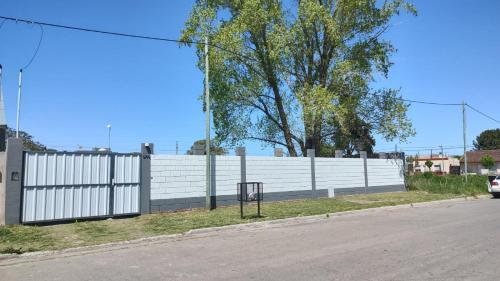 a white fence next to a road at Alamo - Casa pet friendly in Olavarría