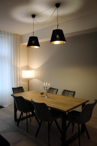 a dining room with a wooden table and chairs at Emajõe Keeltekool Apartment in Tartu