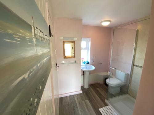 a bathroom with a toilet and a sink at Carlton Cottage Country Retreat - Perfect for Ipswich - Aldeburgh - Southwold - Thorpeness - Sizewell B - Sizewell C - Sleeps 13 in Little Glenham