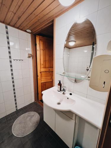 a bathroom with a white sink and a mirror at Rieskapaikka in Koivu