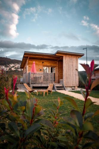 a log cabin with a porch and a deck at Les Lodges de la ViaRhôna / cabane-spa in Virignin