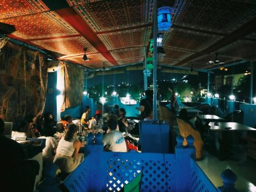 a group of people sitting in a restaurant at Dylan Cafe And Guest House in Jodhpur