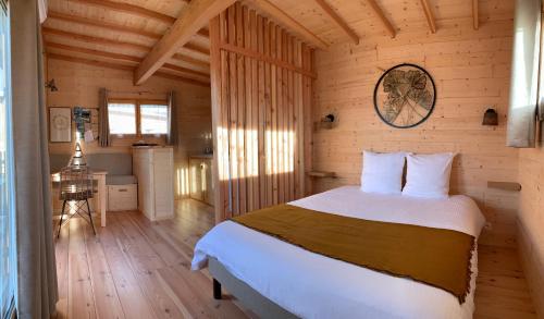 a bedroom with a bed in a wooden cabin at Les Lodges de la ViaRhôna / cabane-spa in Virignin