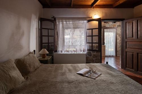 ein Schlafzimmer mit einem Bett mit einem Buch darauf in der Unterkunft Traditionelles Appartement ATHOS SHADOW am Meer in Paralia Sikias