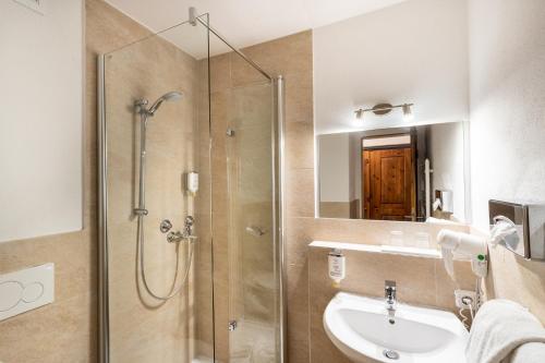 a bathroom with a shower and a sink at Das Bergmayr - Chiemgauer Alpenhotel in Inzell