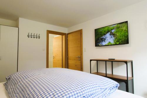 a bedroom with a bed and a tv on the wall at Sport Matt Appartement in Pettneu am Arlberg