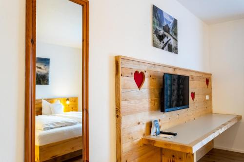 a mirror in a room with a bed and a bedroom at Das Bergmayr - Chiemgauer Alpenhotel in Inzell