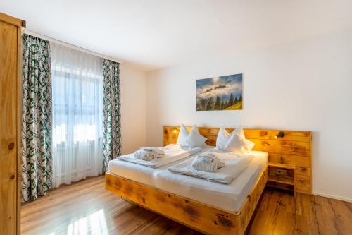 a bedroom with a bed and a large window at Das Bergmayr - Chiemgauer Alpenhotel in Inzell