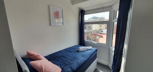 a room with a blue couch next to a window at Stoke City House in Etruria