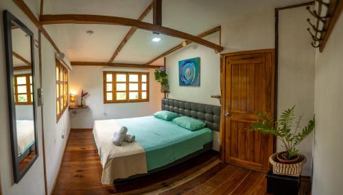 a bedroom with a bed with blue pillows at Rancho Mila in San Vicente
