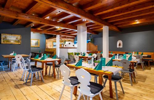 a restaurant with wooden floors and tables and chairs at Das Bergmayr - Chiemgauer Alpenhotel in Inzell