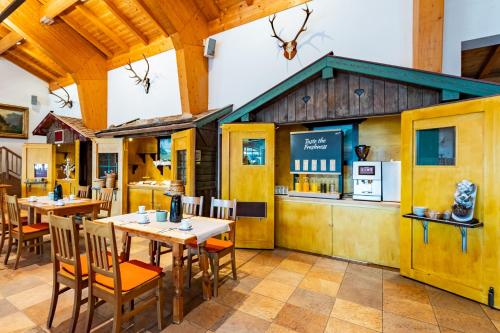 a restaurant with tables and chairs and a kitchen at Das Bergmayr - Chiemgauer Alpenhotel in Inzell
