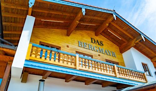 a wooden building with a balcony on the side at Das Bergmayr - Chiemgauer Alpenhotel in Inzell