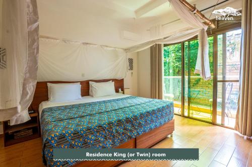a bedroom with a bed and a large window at Heaven Restaurant & Boutique Hotel in Kigali