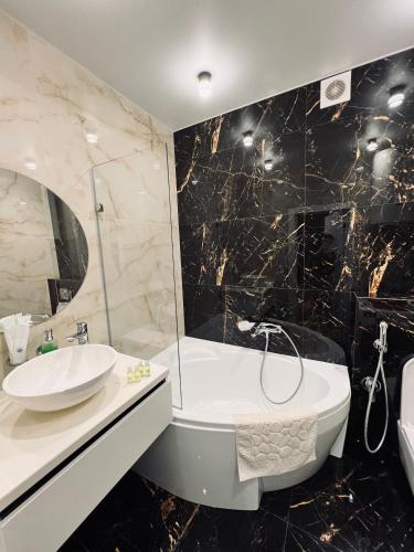 uma casa de banho com um lavatório, uma banheira e um WC. em Exclusive apartment Новобудова ЖК Театральний ЦЕНТР em Rivne