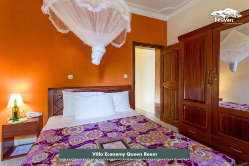 a bedroom with a bed with orange walls at Heaven Restaurant & Boutique Hotel in Kigali