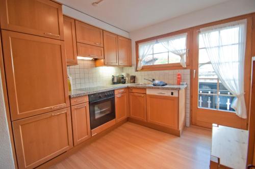 a kitchen with wooden cabinets and a window at Dent Blanche in Zermatt
