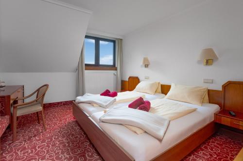 ein Hotelzimmer mit einem Bett mit Handtüchern darauf in der Unterkunft Hotel Schomacker in Lilienthal