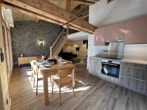 une cuisine et une salle à manger avec une table et des chaises dans l'établissement POLARIS Bel appartement village et pistes, à La Clusaz