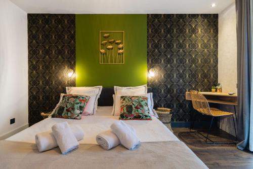 サン・ジャン・ド・モーリエンヌにあるChambre D'hôtes Chez Domの緑の壁のベッドルーム1室(白い枕付きのベッド1台付)