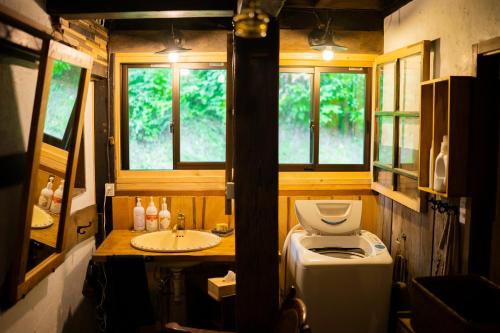 a small bathroom with a toilet and a sink at 古民家宿Tani House Itaya -セルフチェックイン in Tokamachi
