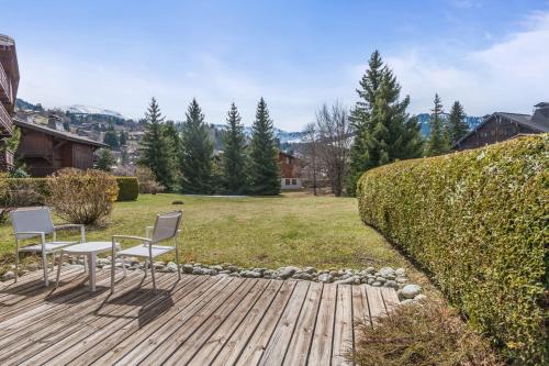 deux chaises et une table sur une terrasse en bois dans l'établissement Appartement Lanura - Welkeys, à Megève